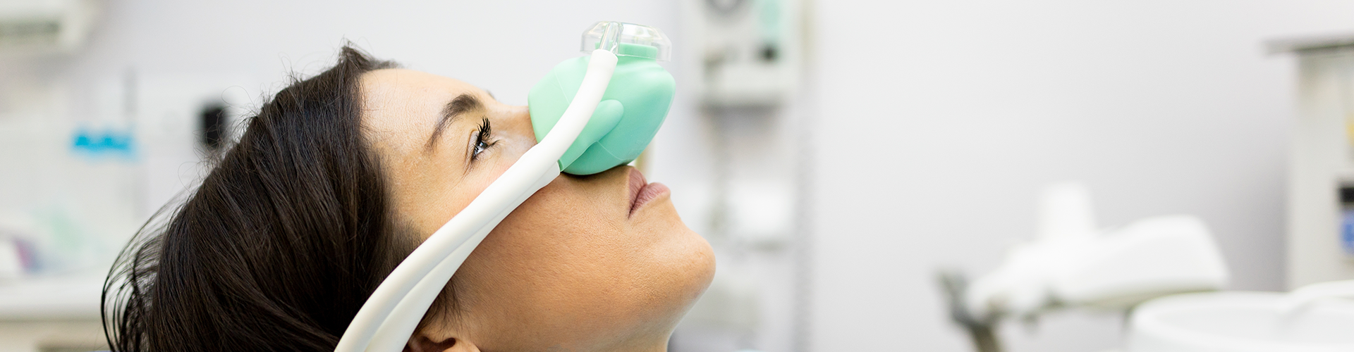 woman in dental chair with breathing mask over her nose